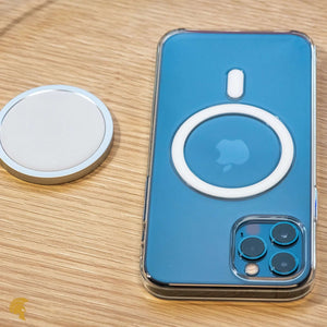 iPhone mit transparenter MagSafe-Hülle und MagSafe-Ladegerät auf einem Holztisch. Perfekt für kabelloses Laden und MagSafe-Zubehör.