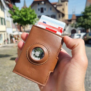 SPARTANHUB Elite Wallet – RFID-geschütztes Elite Wallet in braun mit AirTag-Halterung, gehalten in Hand.