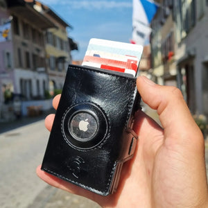 SPARTANHUB Elite Wallet – RFID-geschütztes Elite Wallet in schwarzer mit AirTag-Halterung, gehalten in Hand.