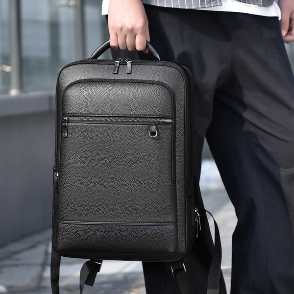 Mann trägt den schwarzen Slim Pack Rucksack von SPARTANHUB in der Hand – minimalistischer Herren-Rucksack im Business- und Streetstyle-Look.